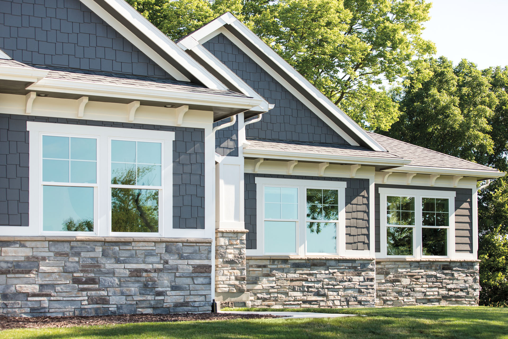 The lovely exterior of a modern home, featuring sparkling windows and new siding.